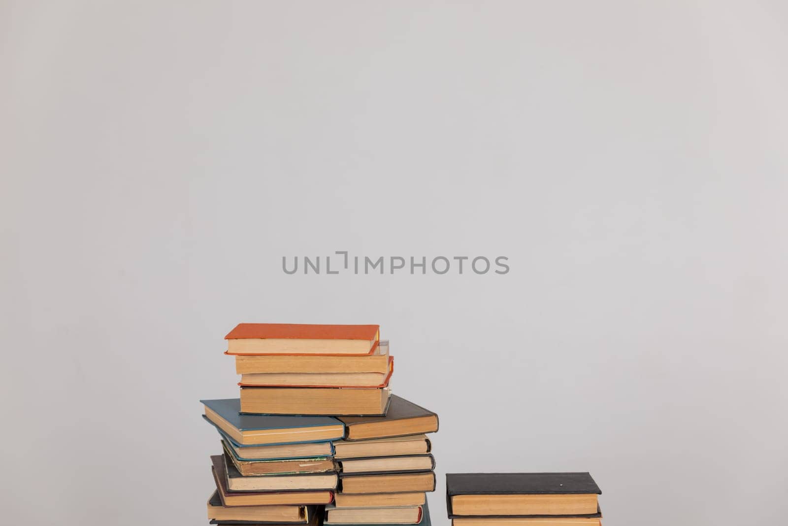 Stacks of old educational books for learning on a white background