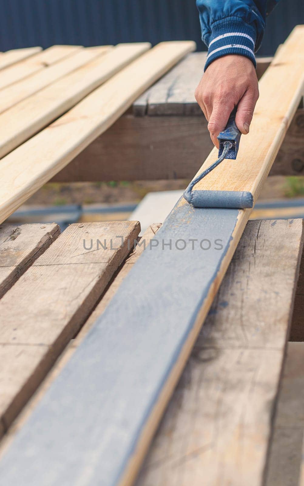 A man paints a board with paint. Selective focus. People.