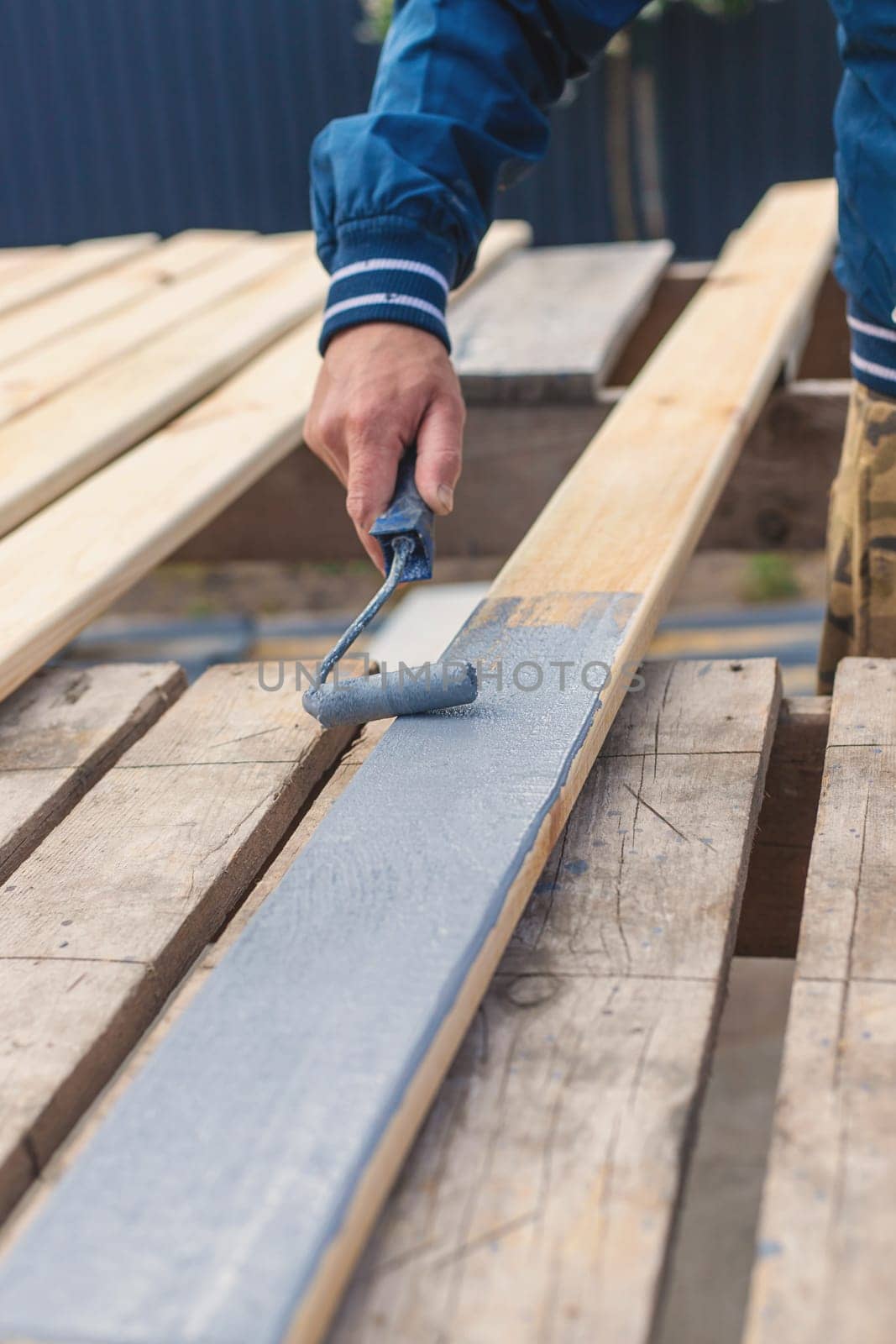 A man paints a board with paint. Selective focus. People.