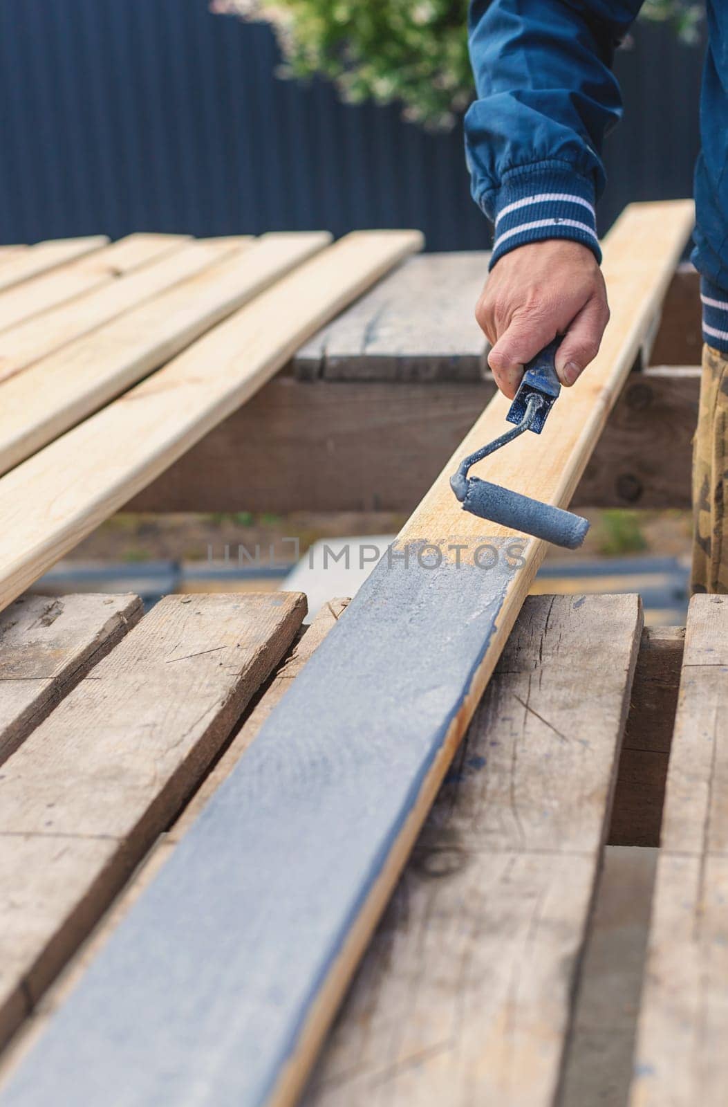 A man paints a board with paint. Selective focus. People.
