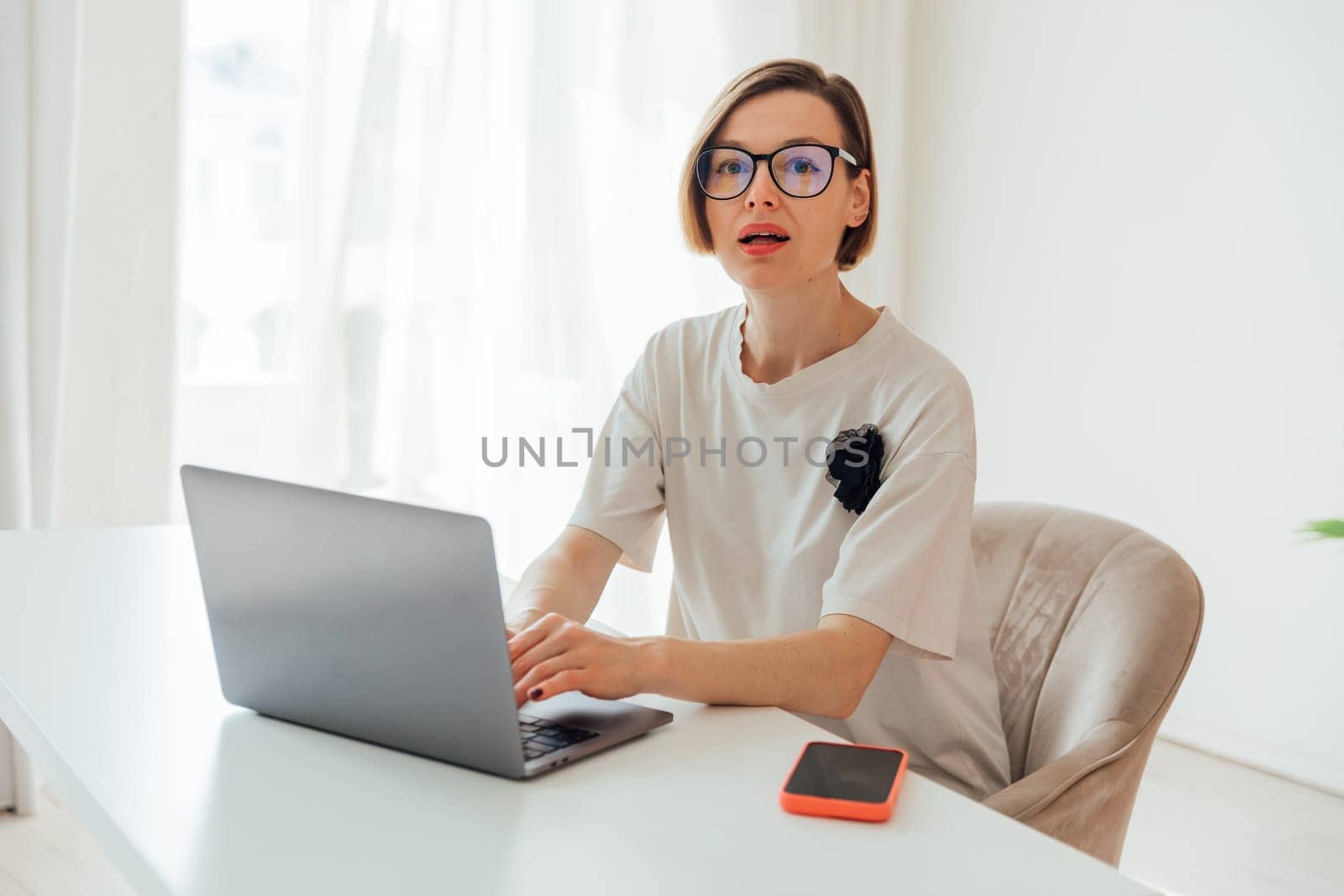 Business woman in glasses working at desk with laptop in office online