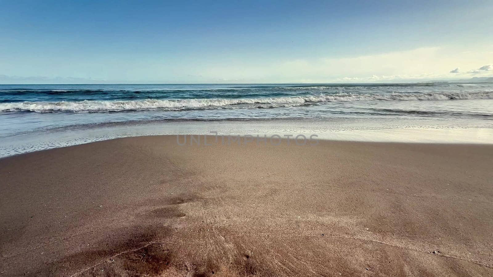 A calm beach with gentle waves and soft sand, creating a perfect setting for relaxation and escape from daily life