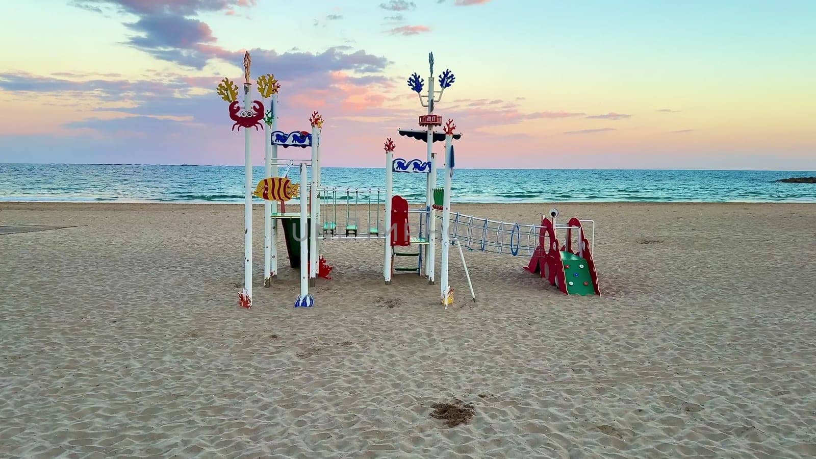 A vibrant and lively beach playground showcasing imaginative designs, all set against a breathtaking sunset backdrop