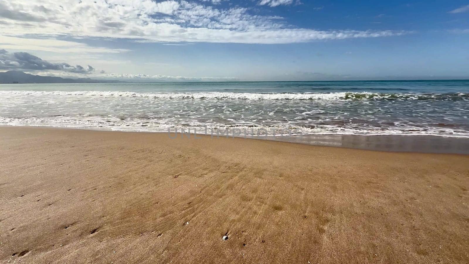 Gentle sea waves on a sandy beach. High quality 4k footage