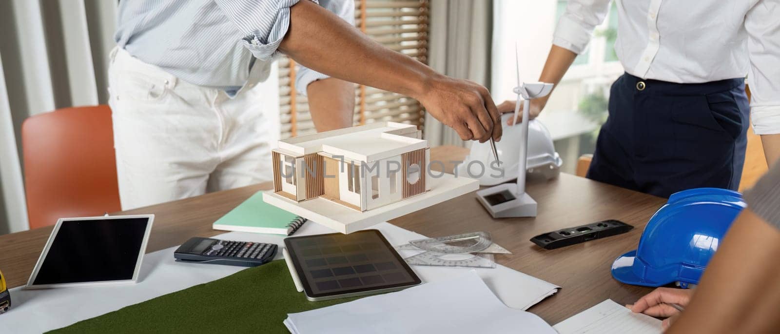 Engineers working at their workstation, skillfully finalizing innovative project designs using high-tech tools and models focused on sustainability.
