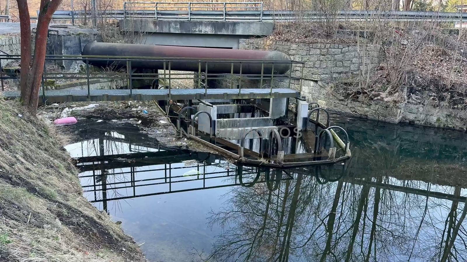 A serene waterway scene featuring industrial elements and stunning reflections. Nature meets machinery.
