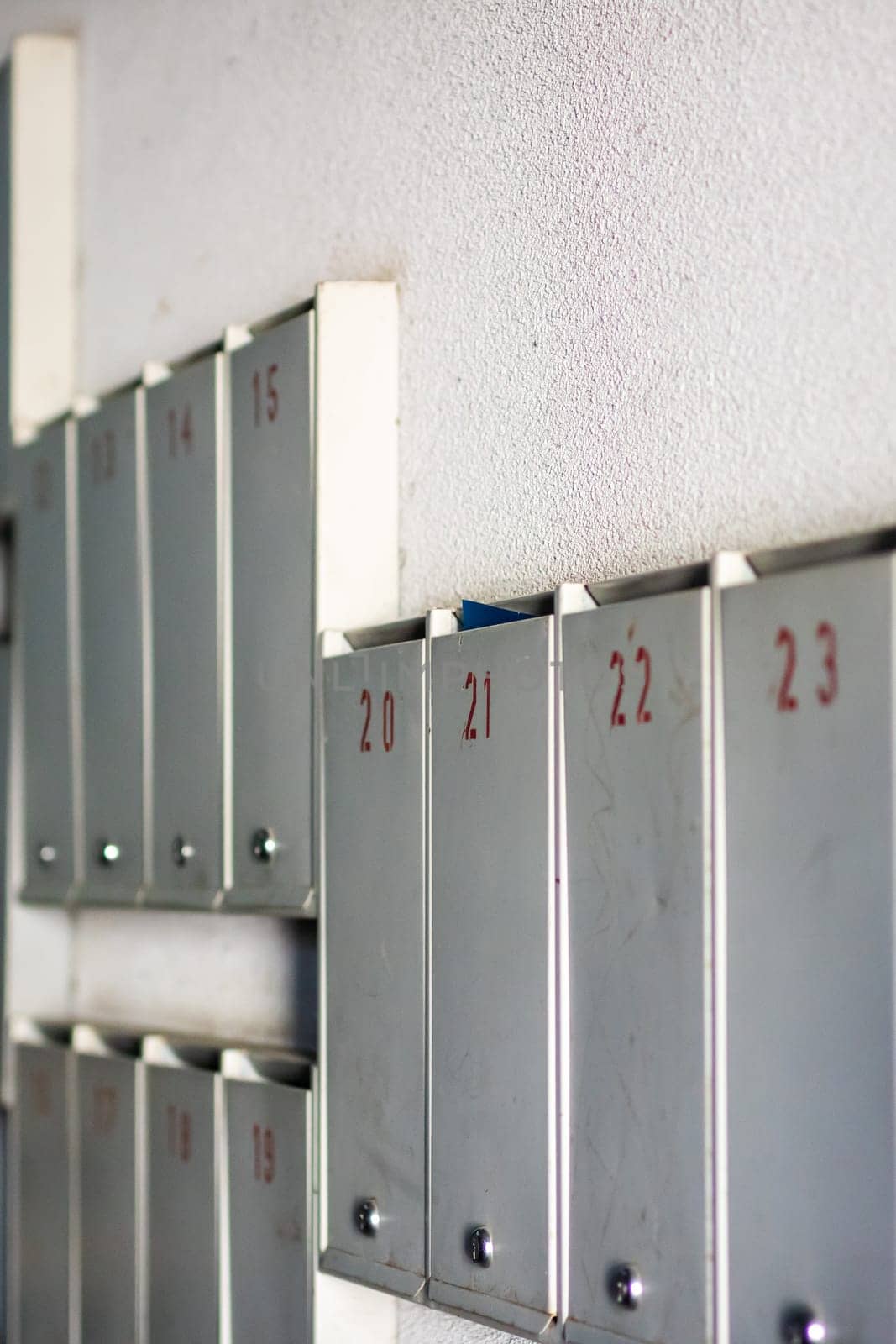 A neat row of metallic lockers proudly displaying the number 23 on each of them, reflecting the shine of silver and aluminium materials