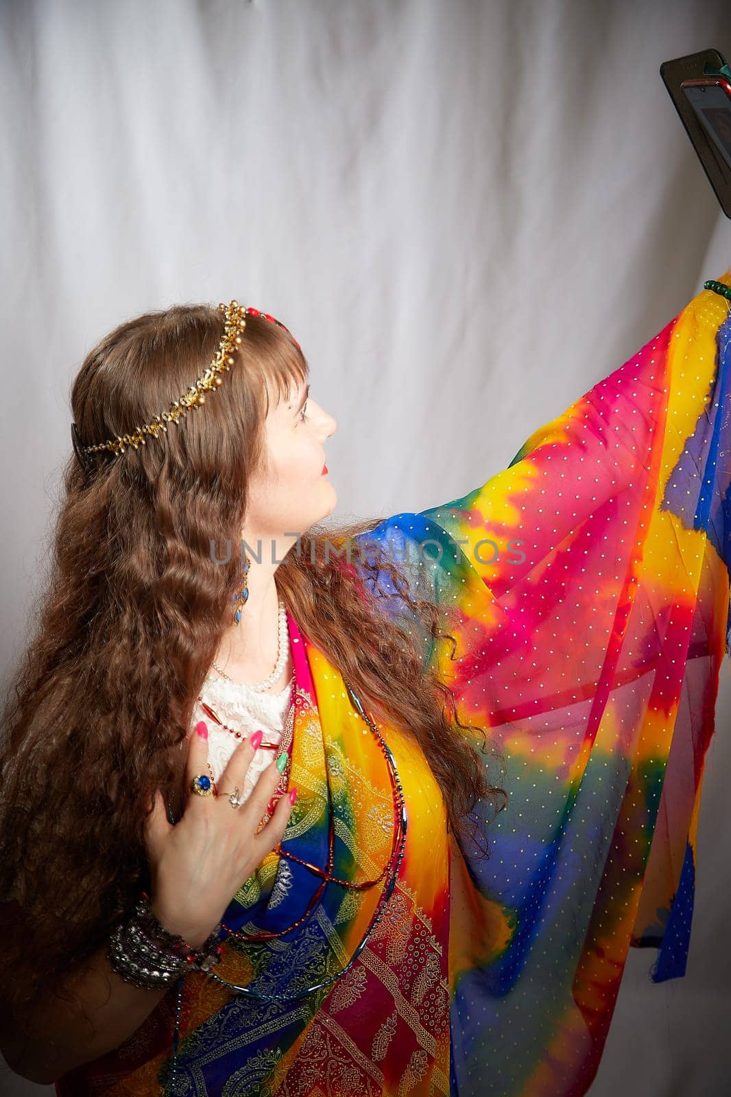 Blonde woman showcases her elegance in a colorful sari during an Indian-inspired photoshoot, exuding confidence and grace while posing.