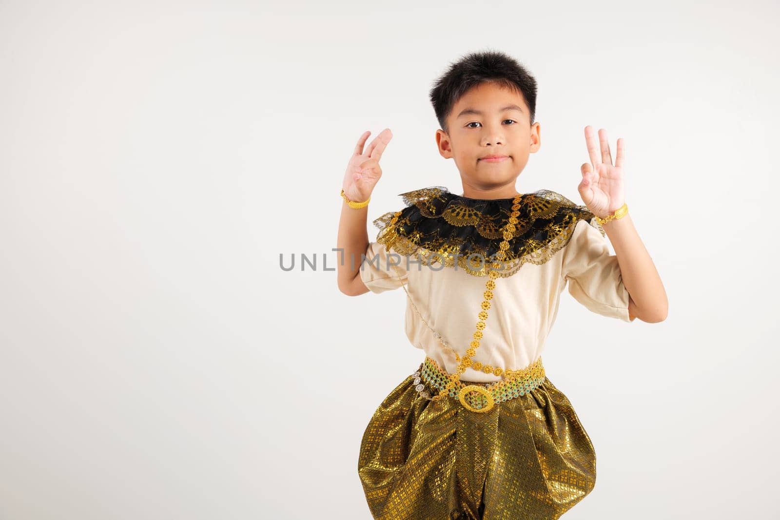 Portrait Thailand kid boy smiling traditional Thai dress costume showcases the OK sign with smile, conveying agreement and positivity, studio isolated white background, primary child success sign