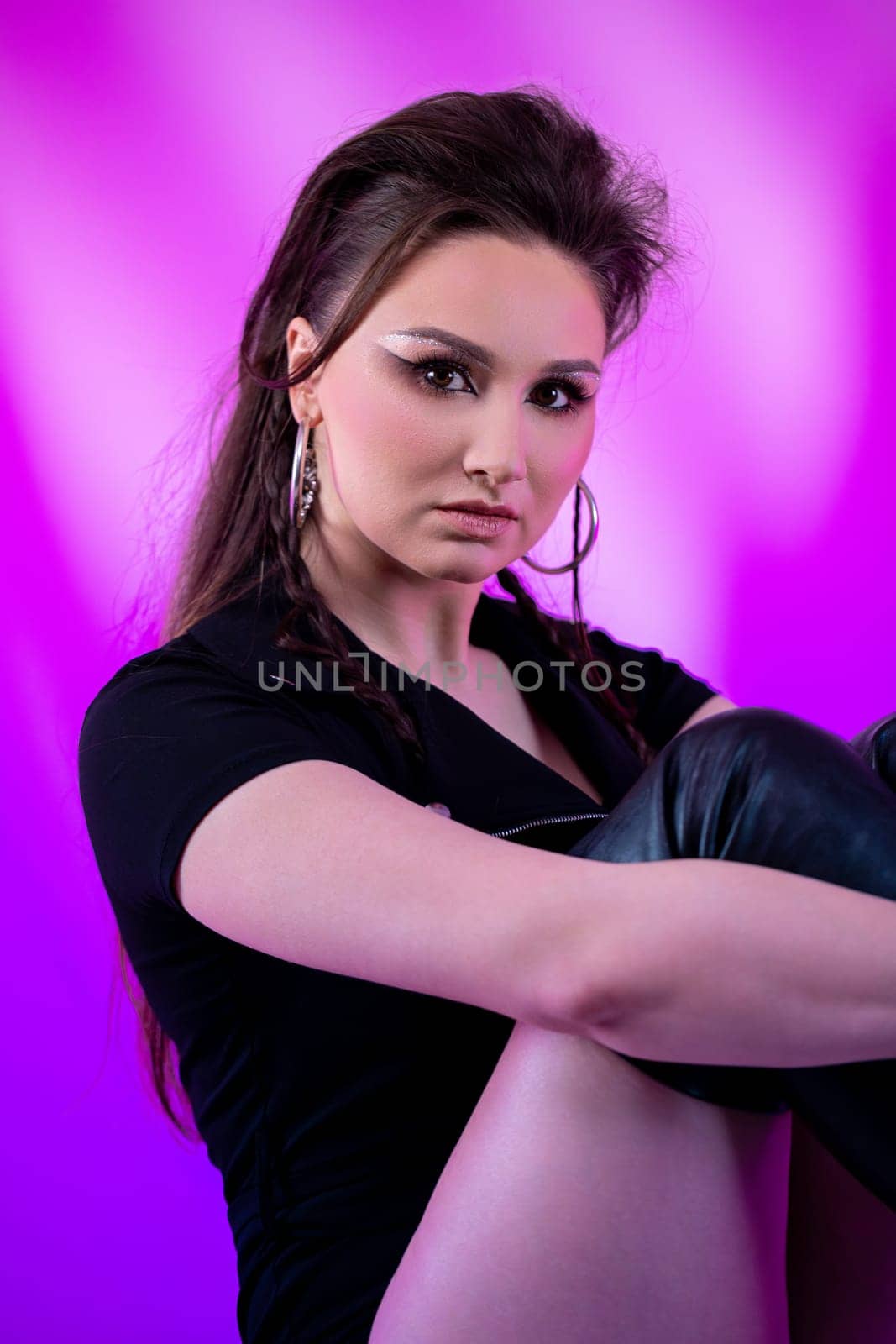A fashionable and trendy young woman poses confidently, showcasing her bold style with vibrant and bold colors