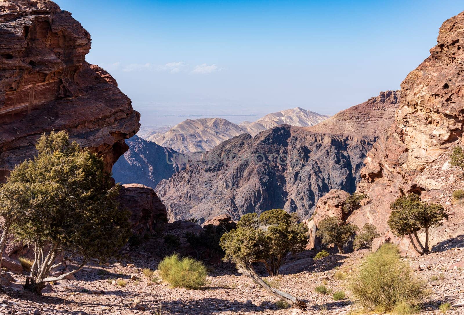 View from the top of the trail to the Monastery of rocky mountain range and gorges with Wadi Araba desert in distance