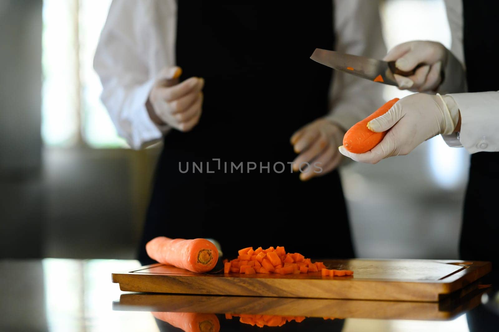 Cooking students slicing vegetables during a cooking class.