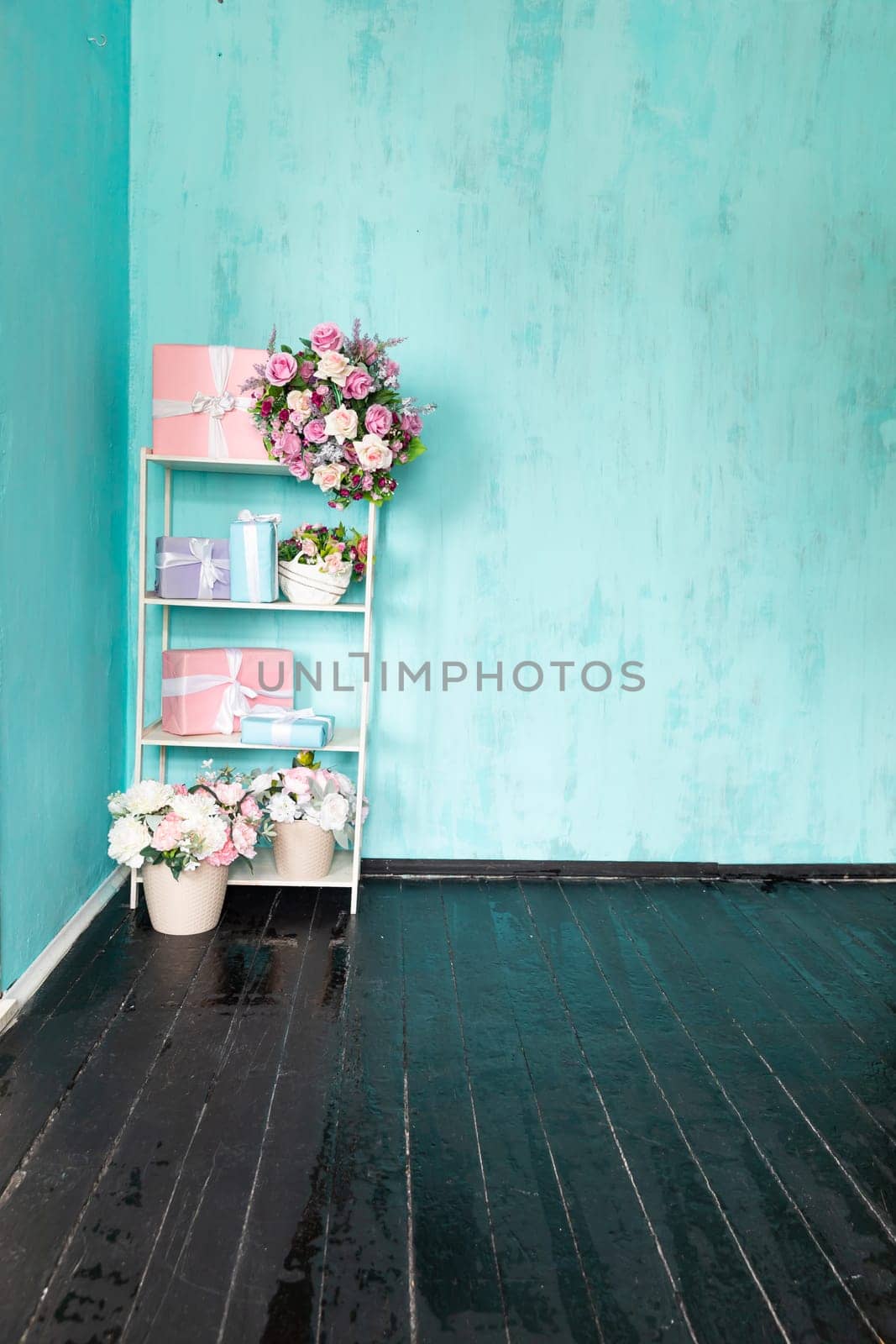 Gift shelves with a vase of flowers in the interior of a blue room