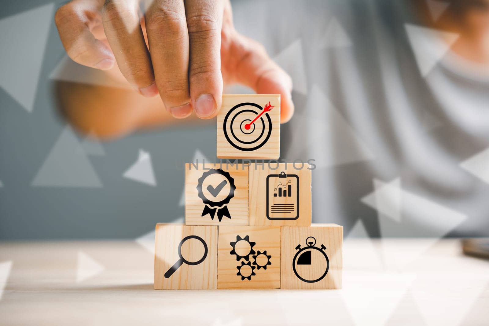 Hand skillfully stacking wood blocks on a table, representing the concept of business strategy and Action plan. Copy space available for professional use.