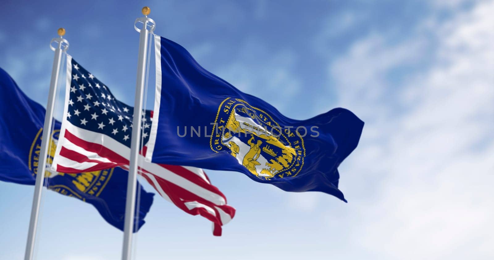 Nebraska state flag waving with the American flag on a clear day. Dark blue with a large state seal of Nebraska at its center. 3d illustration render. Rippling fabric. US state flag