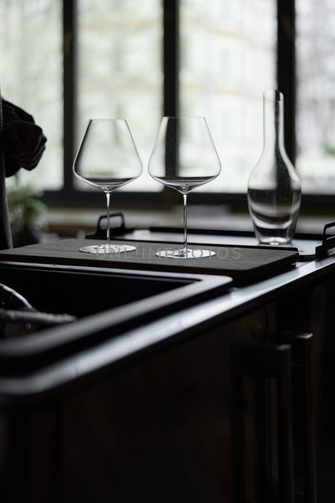 Clean wine glasses and decanter are on the table of a special wine cabinet, stylish table setting, ice, light from window, decoder and degasser. High quality photo
