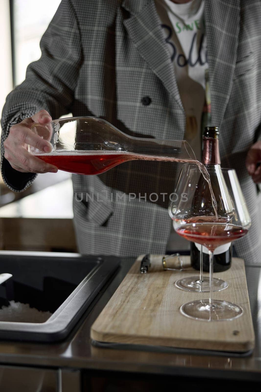 Champagne tasting, The sommelier pours sparkling wine from the decanter into a beautiful glass, Wine glasses are on the table, stylish table setting, sparkling wine bubbles. High quality photo