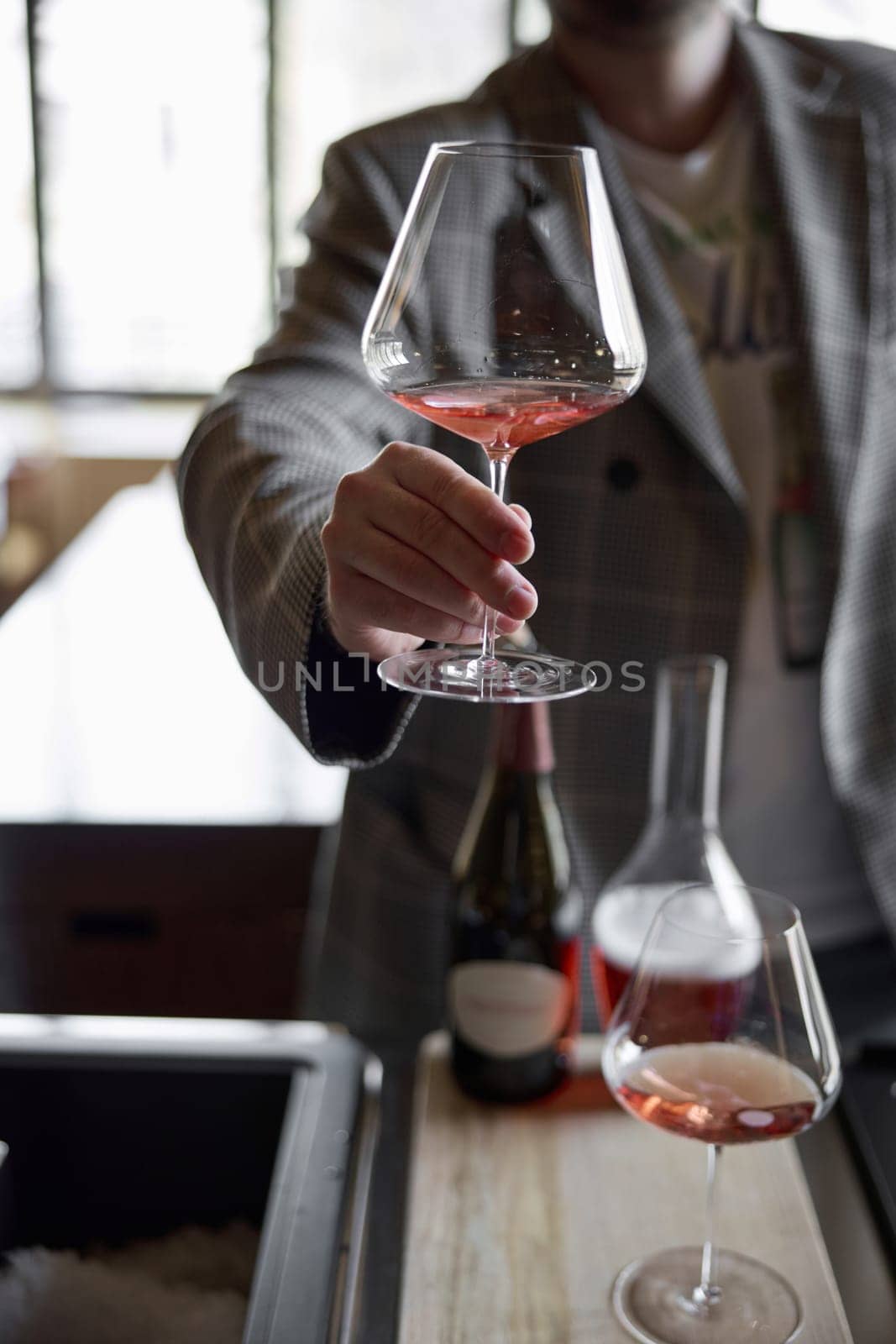 Champagne tasting in restaurant, A man holds in his hand a beautiful elegant glass with rose sparkling wine. High quality photo