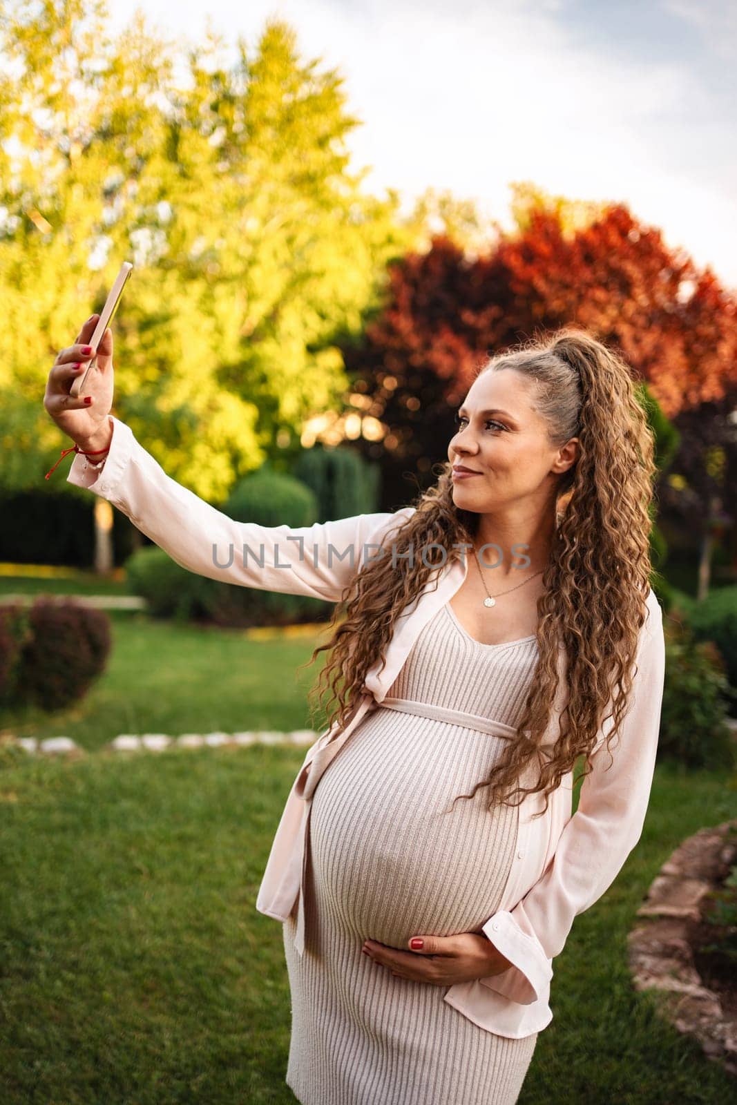 Woman taking a joyful selfie in a blooming garden