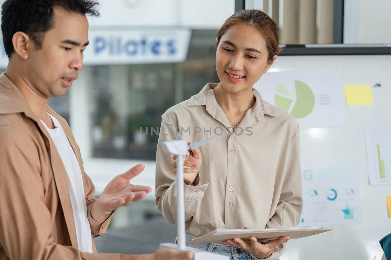 Two professionals engage in a discussion about a wind turbine model, focusing on sustainable practices and corporate ESG initiatives.