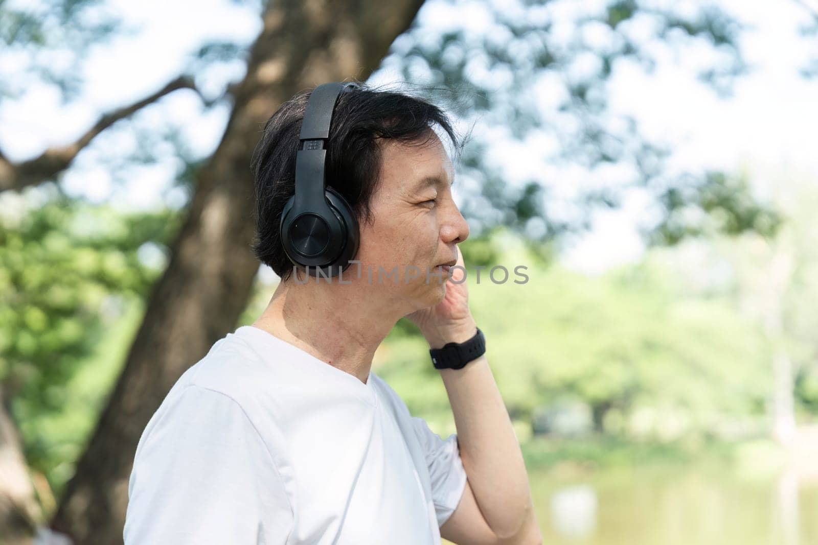 A senior man listens to music in a park, emphasizing the importance of wellness and mental health through music.