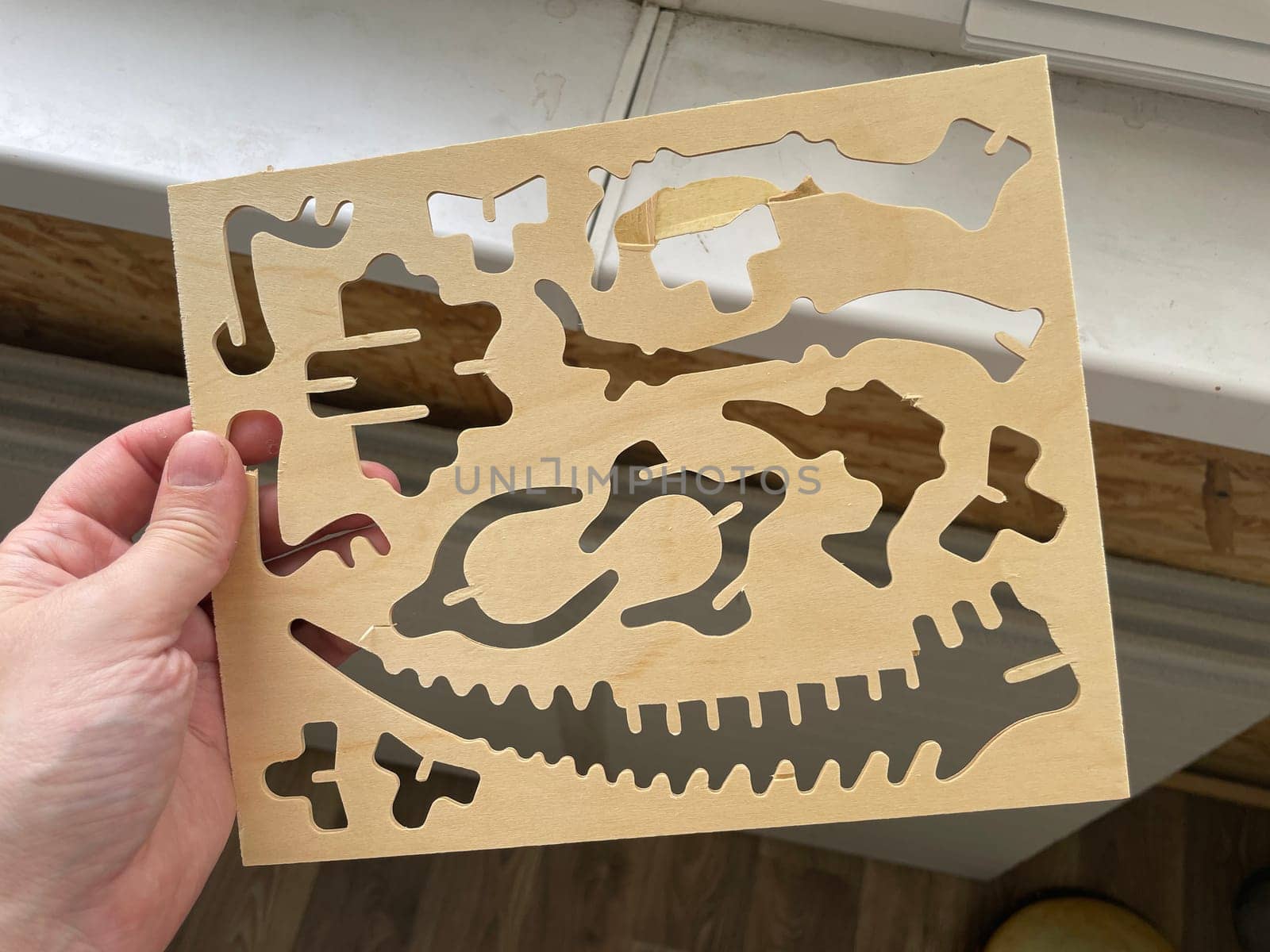 A handcrafted wooden dinosaur model displayed against a clean white background.