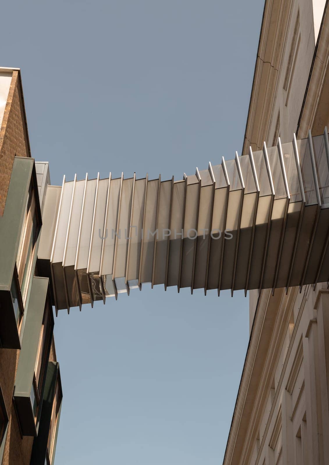 London, UK - May 13, 2025 - Looking up of Bridge of Aspiration with sky background, The futuristic modern of Twisted sky bridge connecting Royal opera house to Royal ballet school in Covent garden, Exterior architectural design of Passageway between buildings, use it as your Wallpaper, Poster and Copy space, Selective focus.