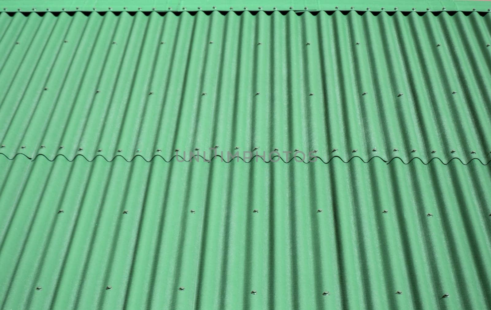 Green wave shaped metal siding, roofing material.