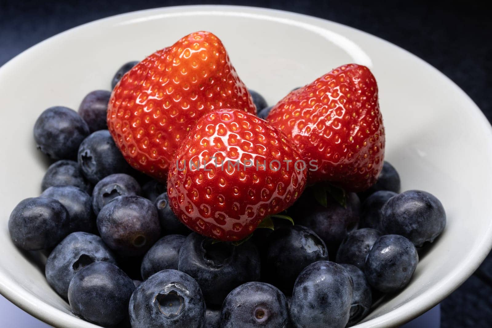Wild strawberry and blueberry with ripe fruit in close up