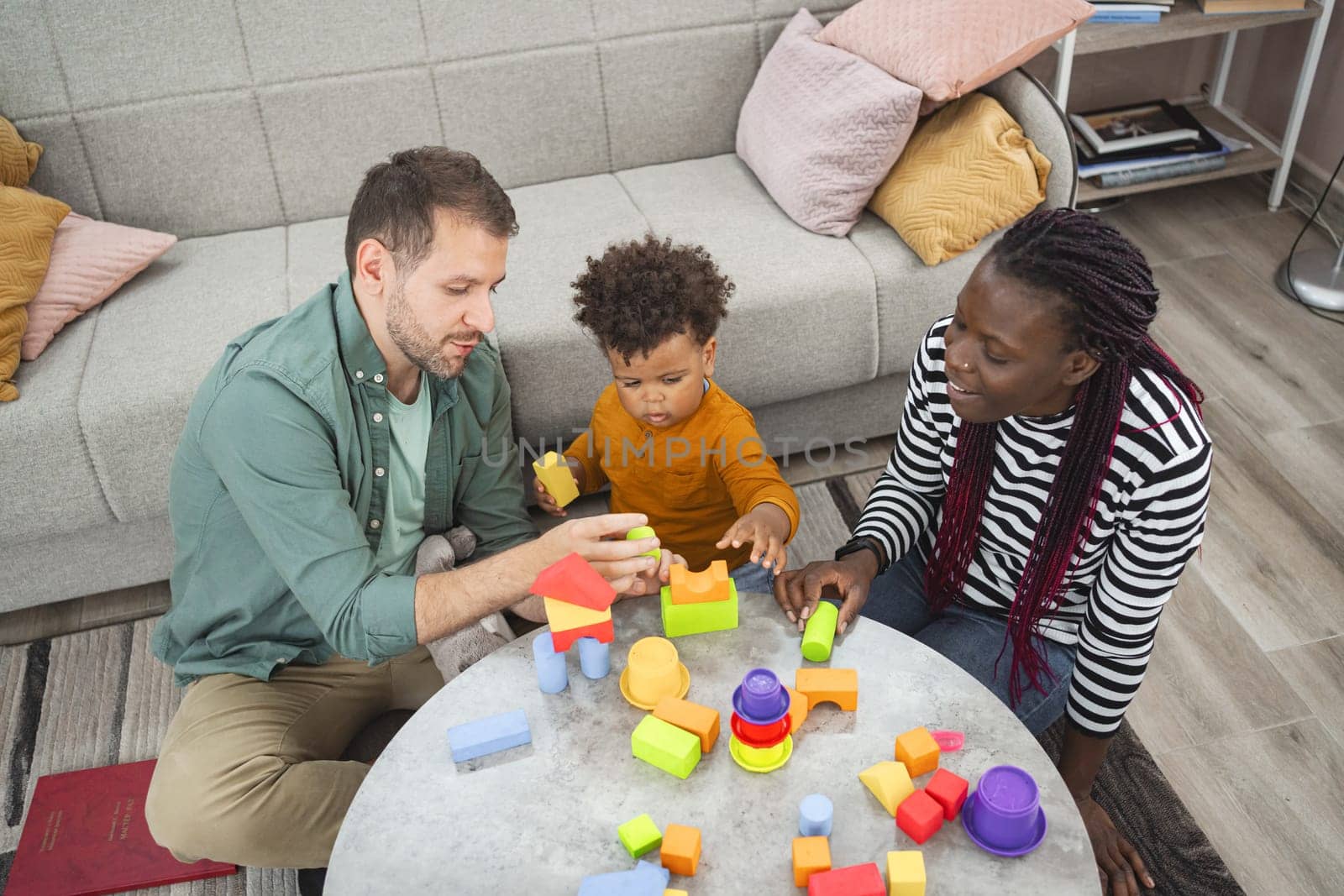 A family enjoys playtime together, building with vibrant blocks at home.