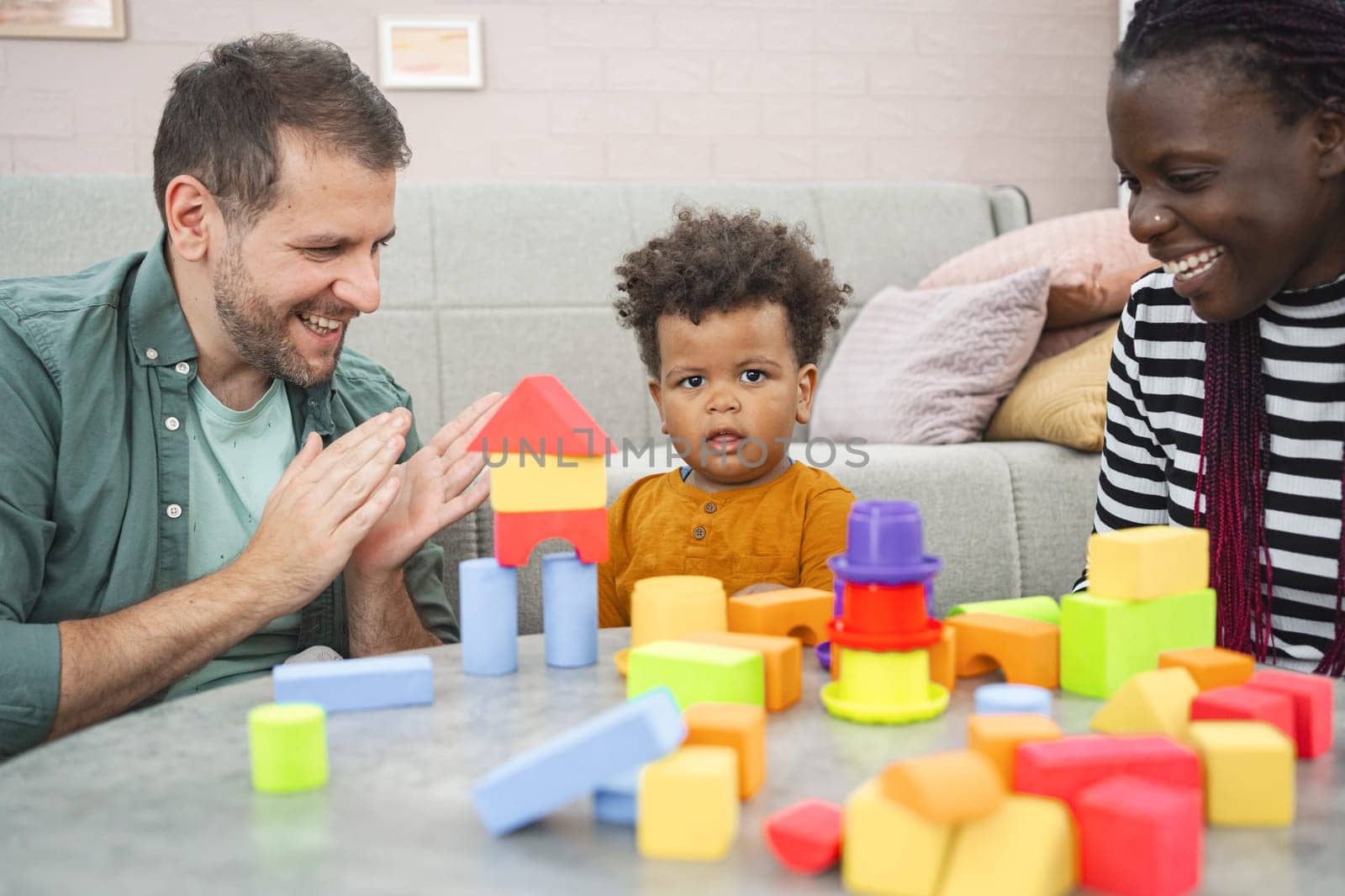 A family has fun playing with colorful building blocks together.