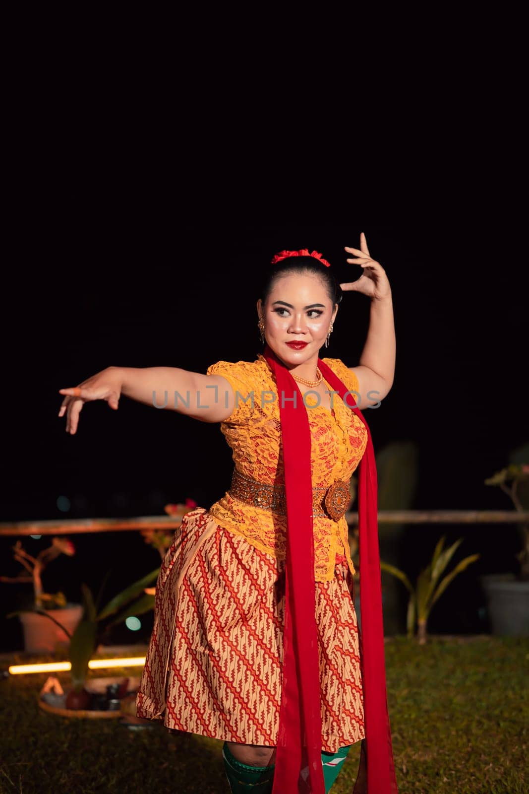 Sundanese woman with an exotic face wearing a yellow dress and red scarf during a dance exhibition at the festival