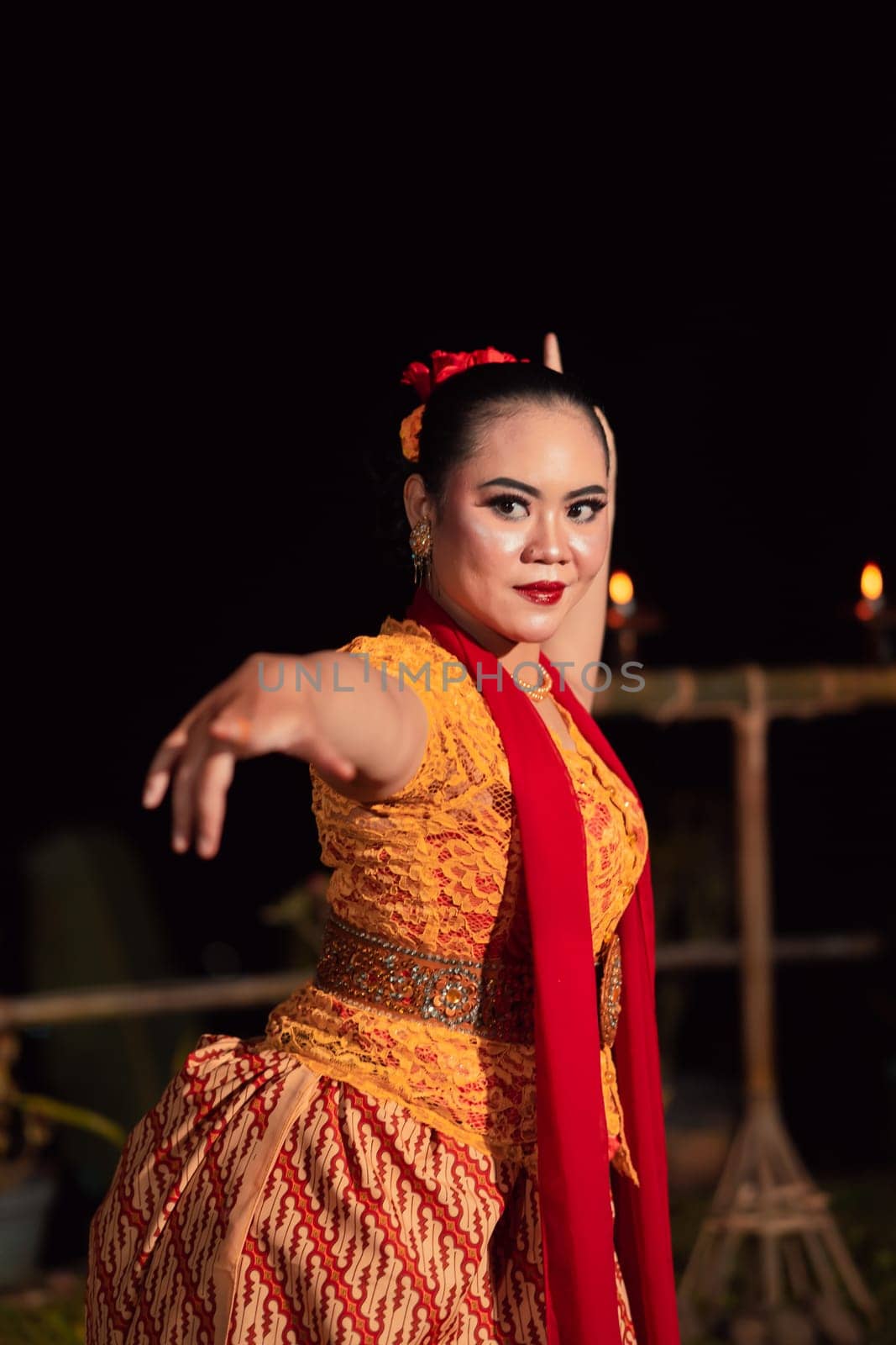 Sundanese woman with an exotic face wearing a yellow dress and red scarf during a dance exhibition at the festival