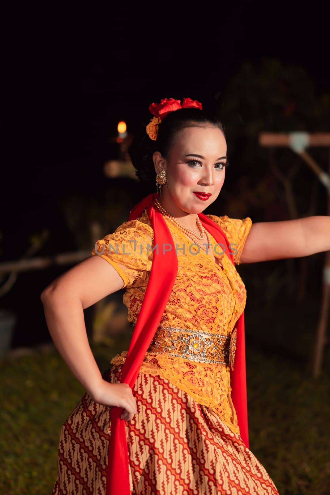 Beautiful Javanese woman with a golden necklace on her neck and golden belt on a yellow dress on their body during the dance performance