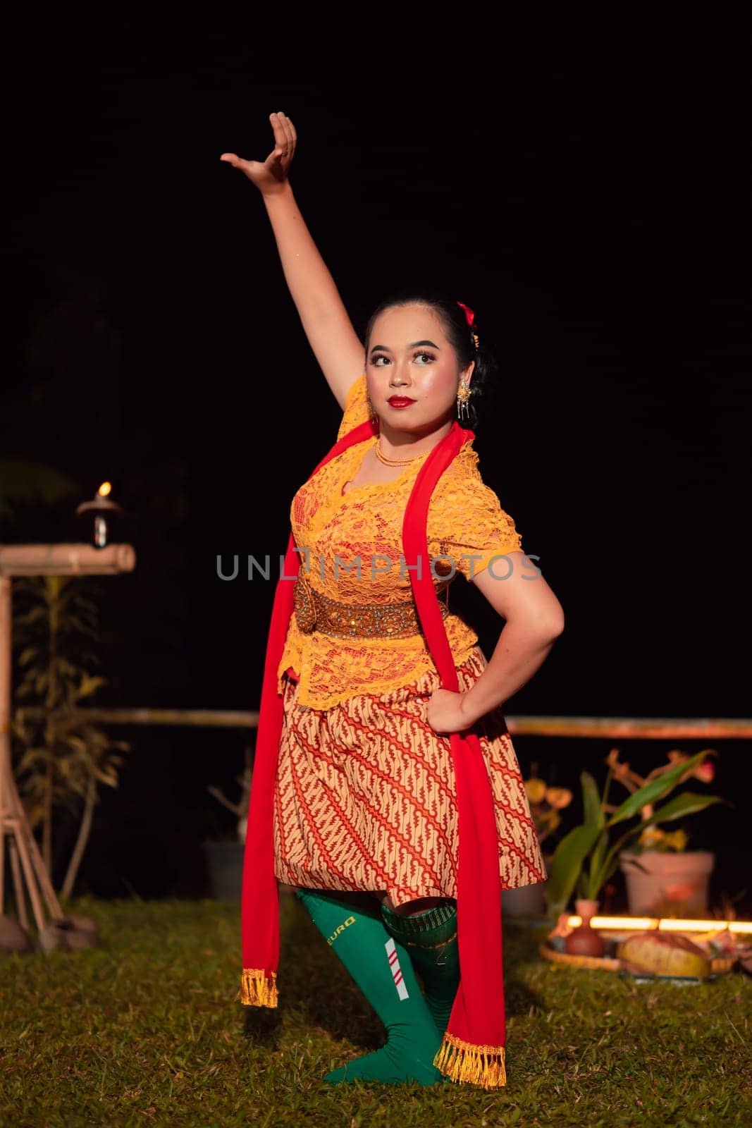 Indonesian women wearing traditional dance costumes called kebaya and pose with dancing moves in the night after the performance