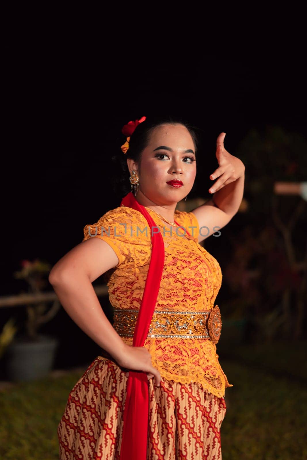 Balinese dancers in yellow color traditional costumes present the dance in front of visitors in a Bali dance performance