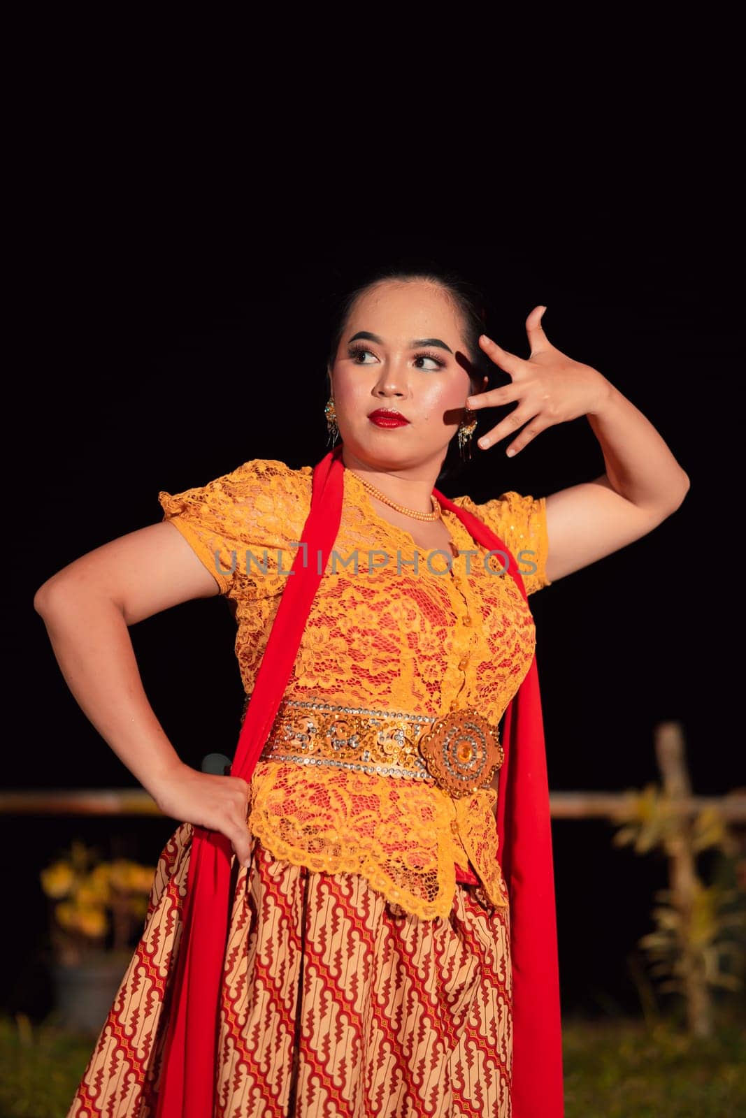 Balinese dancers in yellow color traditional costumes present the dance in front of visitors in a Bali dance performance