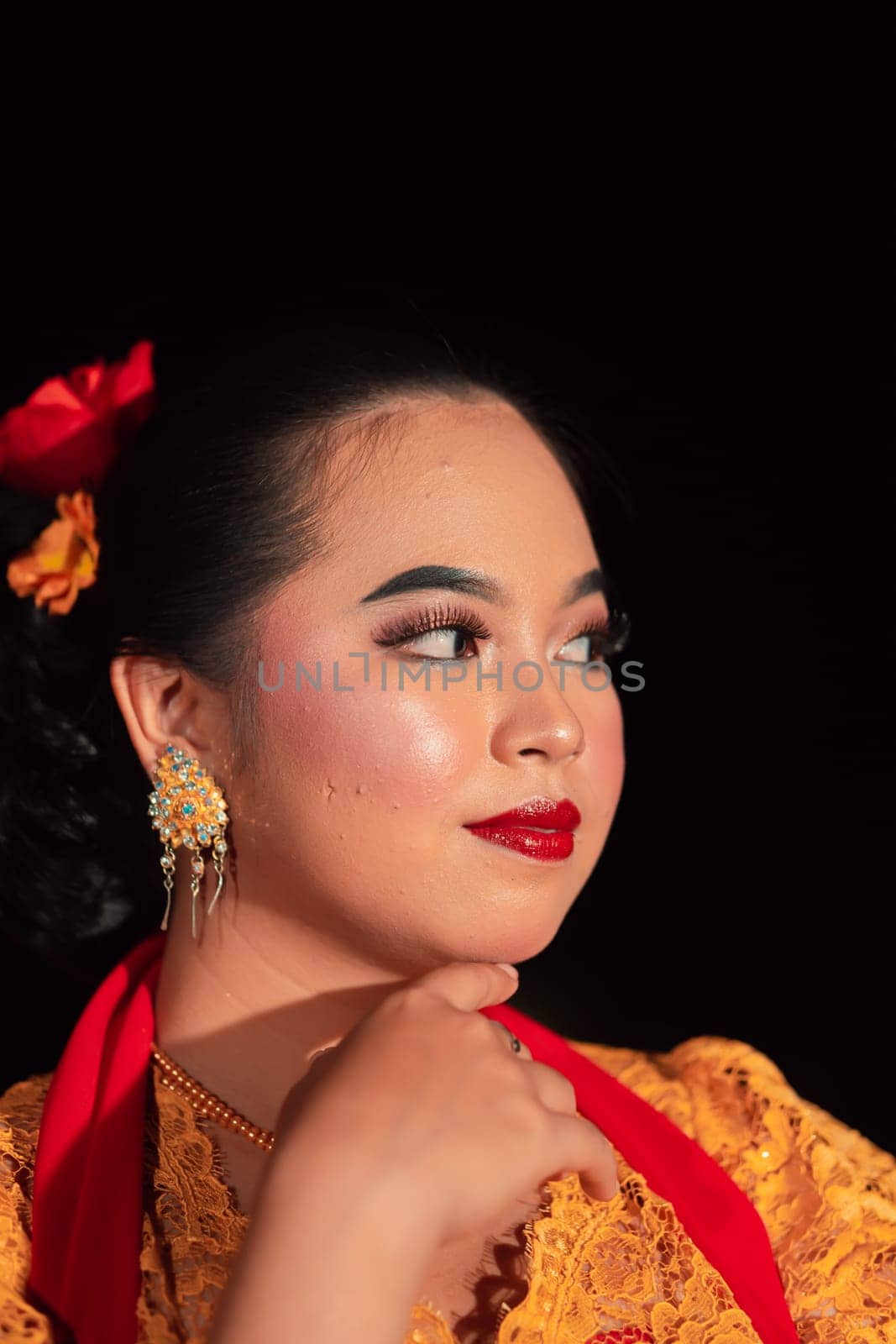 Beautiful face of an Asian woman with red lips and makeup in Indonesian traditional dance costume after the dance performance in the stage