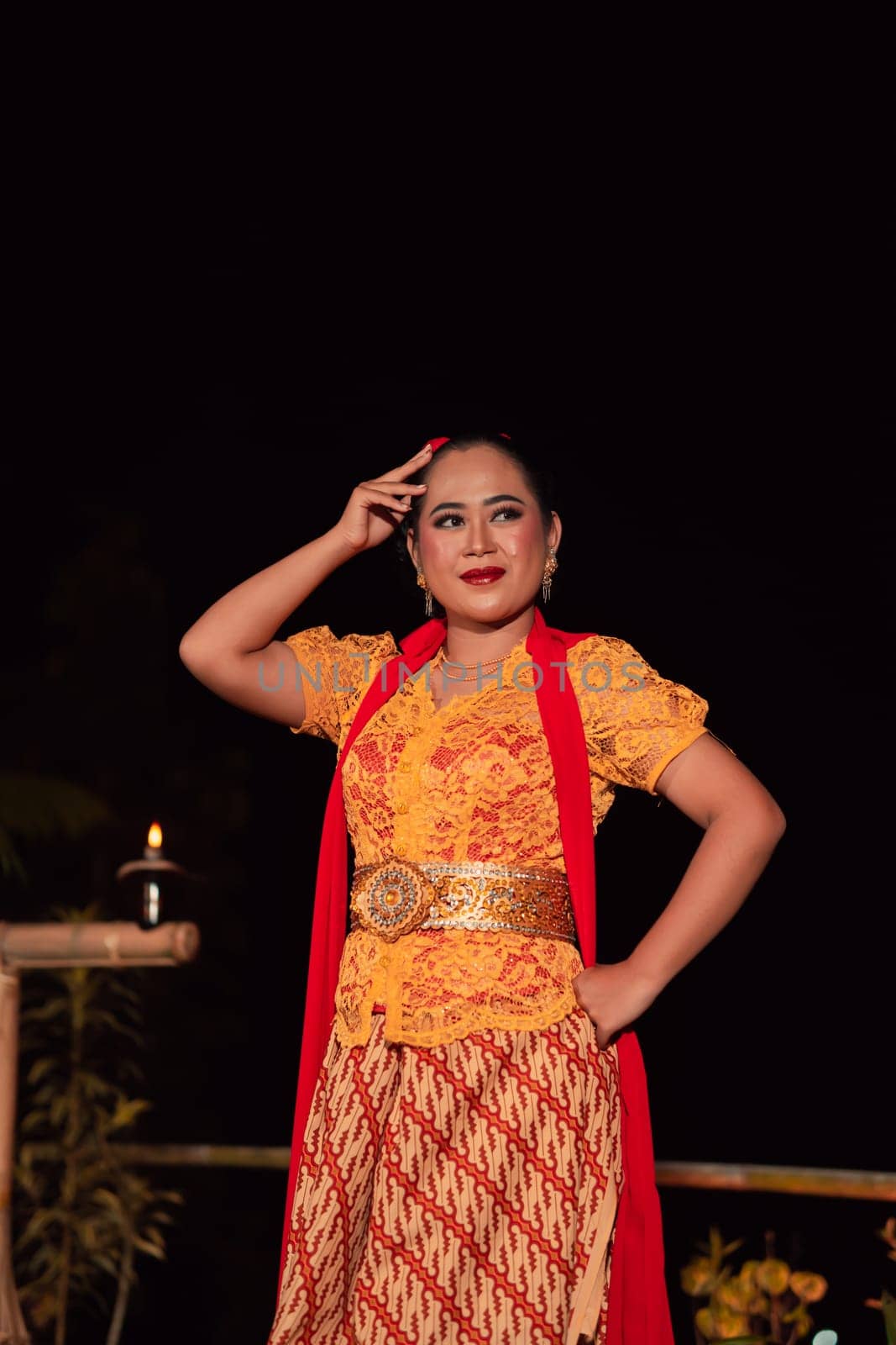 Beautiful Indonesian women wearing an orange traditional dance costume called kebaya when dancing a danced called jaipong inside the festival