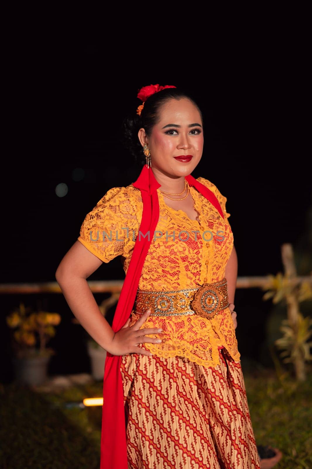 Beautiful Indonesian women wearing an orange traditional dance costume called kebaya when dancing a danced called jaipong inside the festival