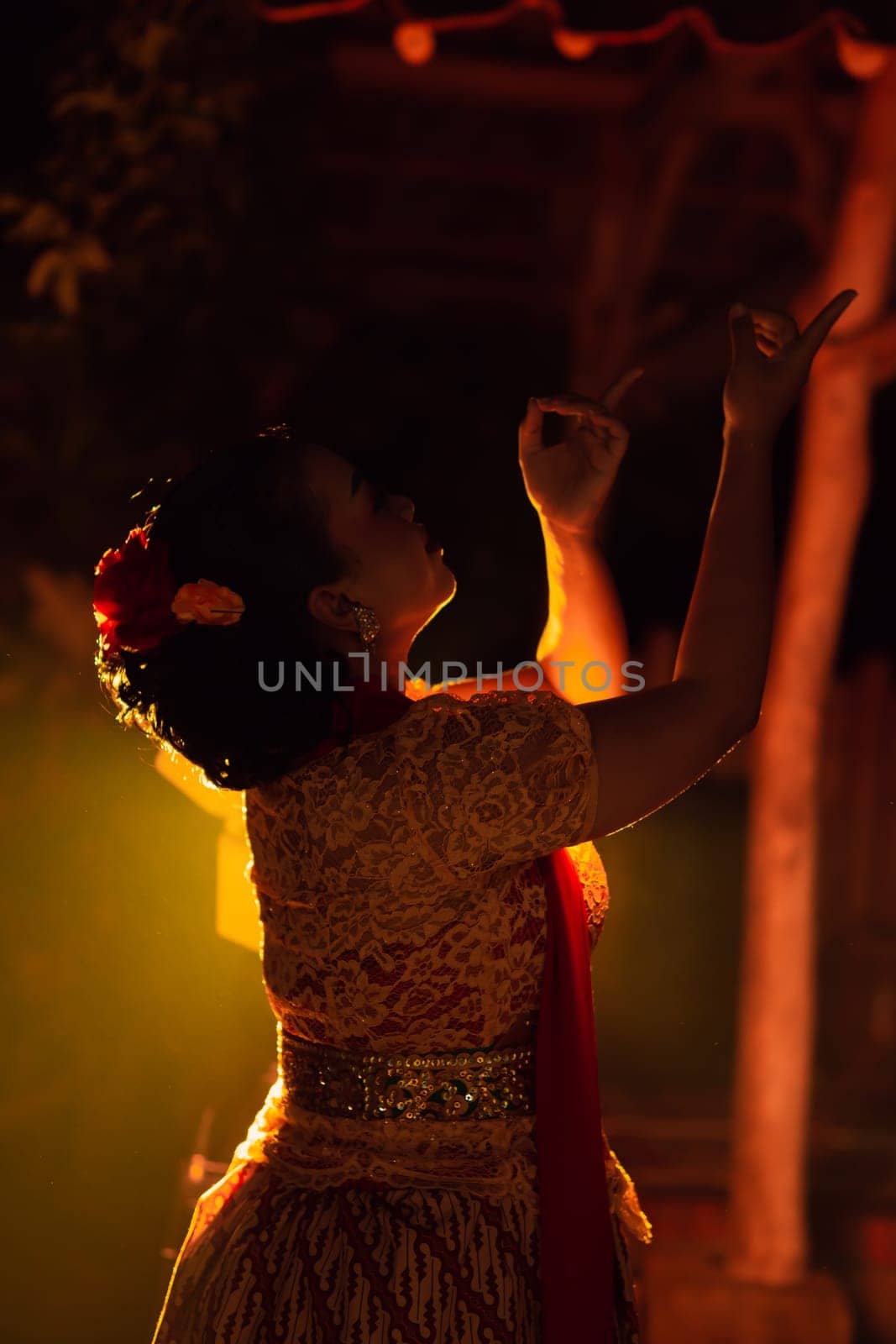 Balinese women wearing cultural clothes while posing in front of the lighting with dancing movements on their body