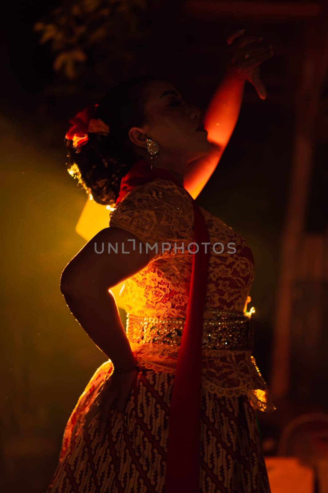 Balinese women wearing cultural clothes while posing in front of the lighting with dancing movements on their body