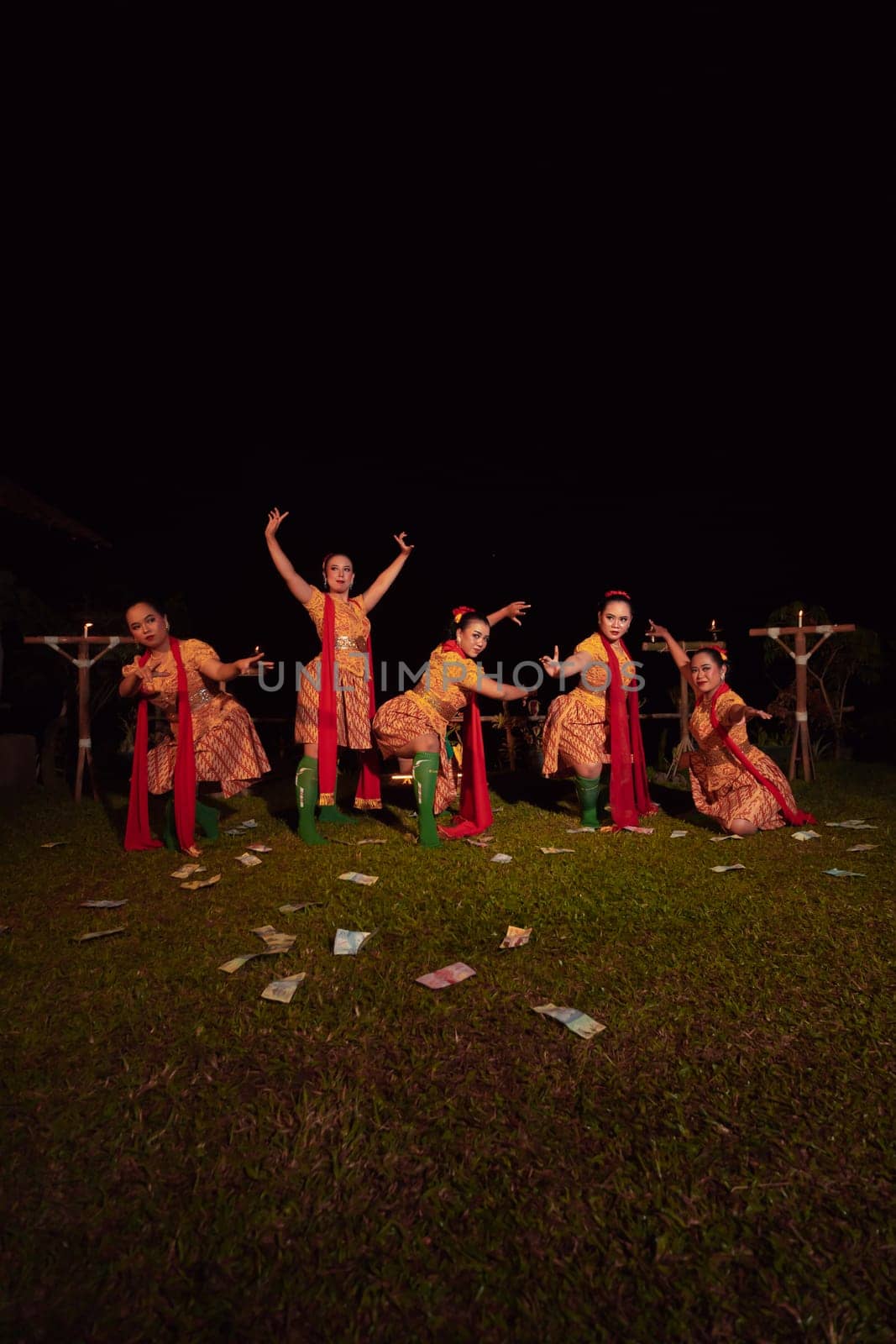 Javanese dancers with beautiful makeup and traditional costume while dancing the traditional dance on the stage inside the village show