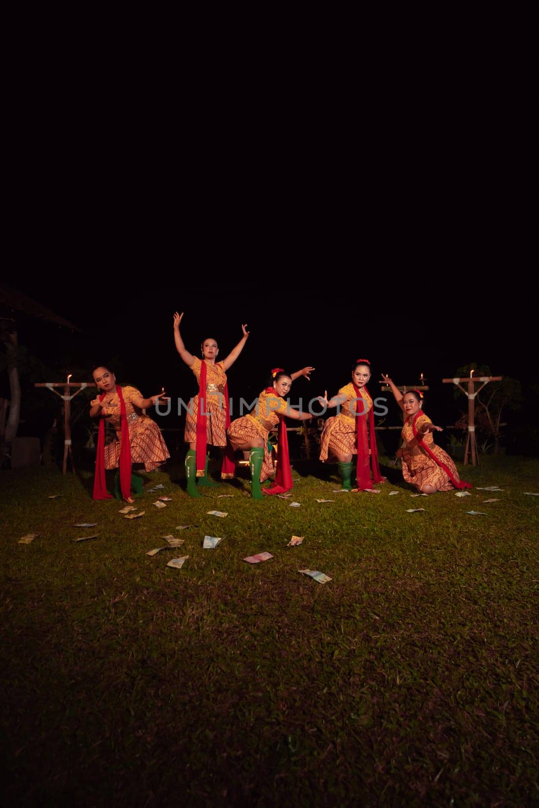 Javanese dancers with beautiful makeup and traditional costume while dancing the traditional dance on the stage inside the village show