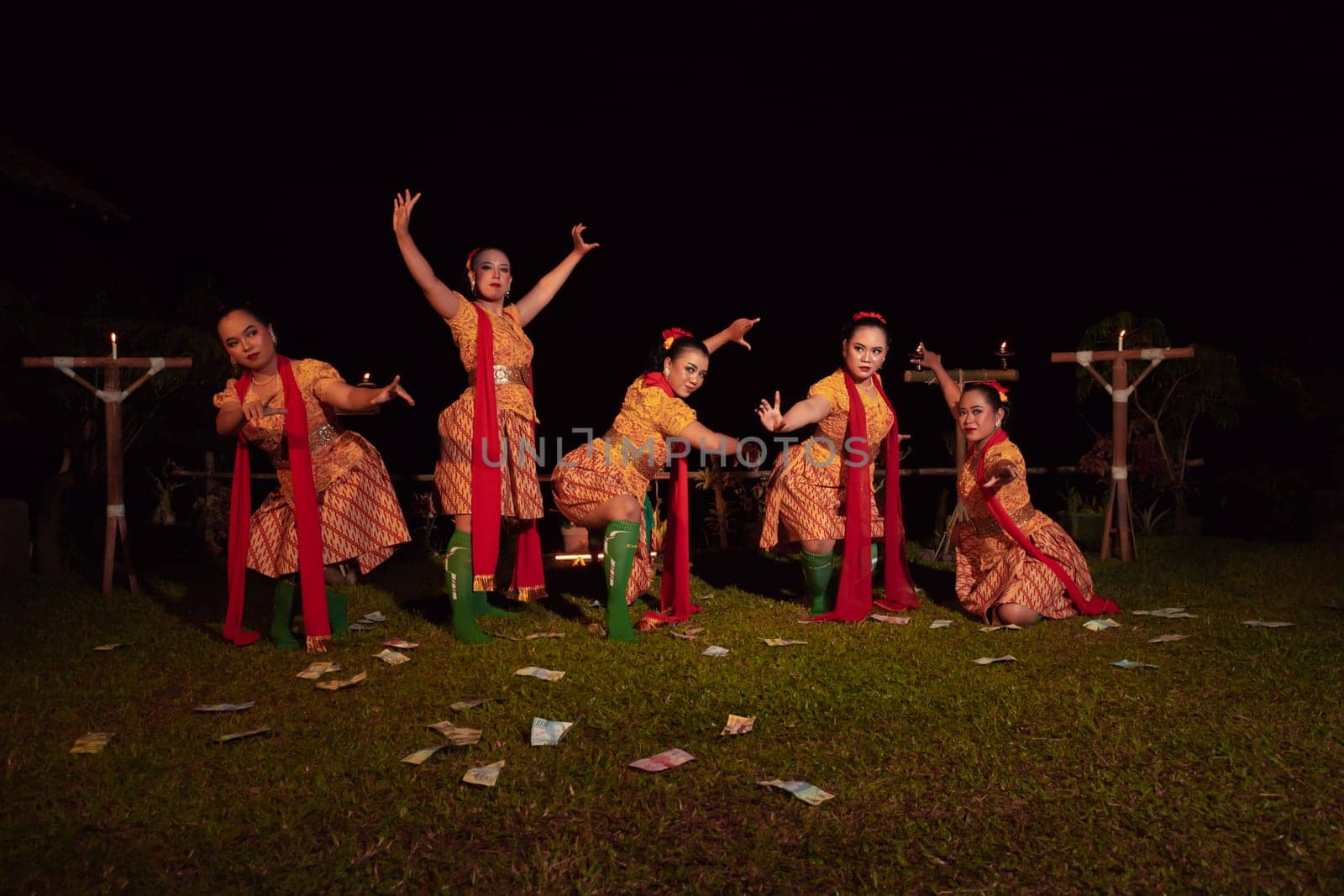 Javanese dancers with beautiful makeup and traditional costume while dancing the traditional dance on the stage inside the village show