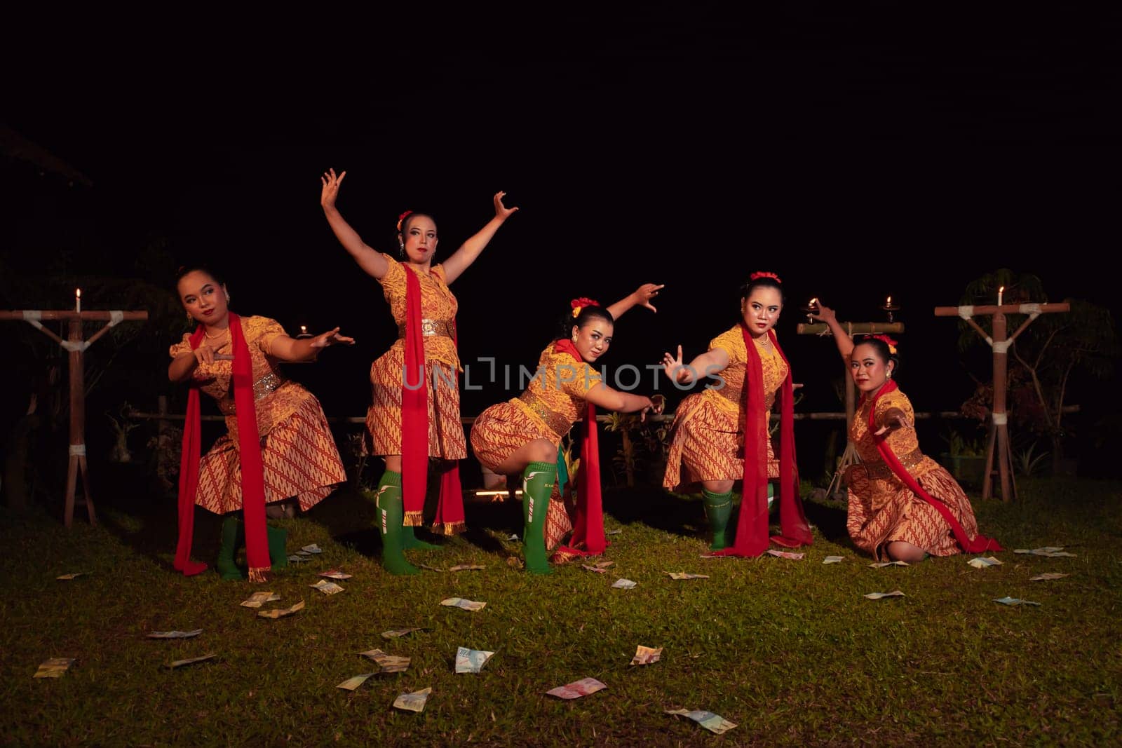 Javanese dancers with beautiful makeup and traditional costume while dancing the traditional dance on the stage inside the village show
