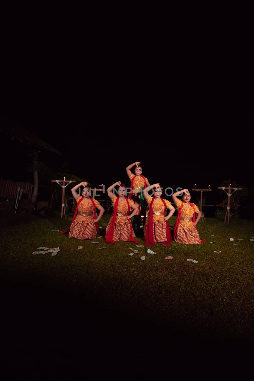 Asian dancers take pose with dance movements while performing the traditional dance in the competition during the night