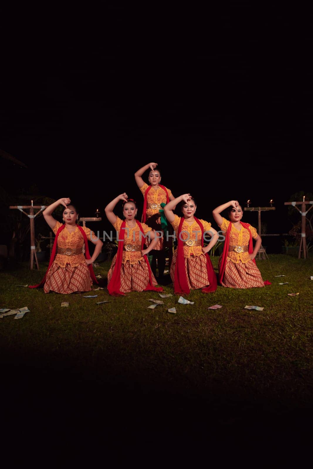 Asian dancers take pose with dance movements while performing the traditional dance in the competition during the night