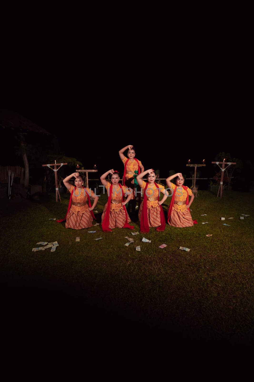 Asian dancers take pose with dance movements while performing the traditional dance in the competition during the night