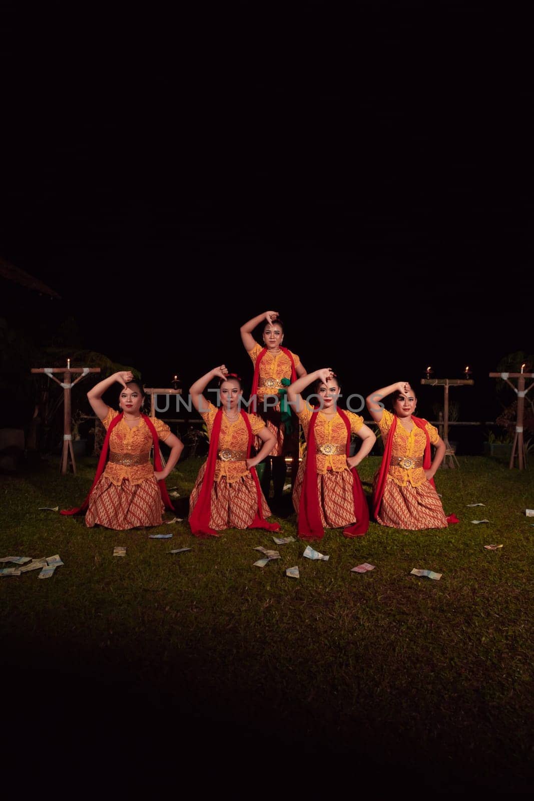 Asian dancers take pose with dance movements while performing the traditional dance in the competition during the night